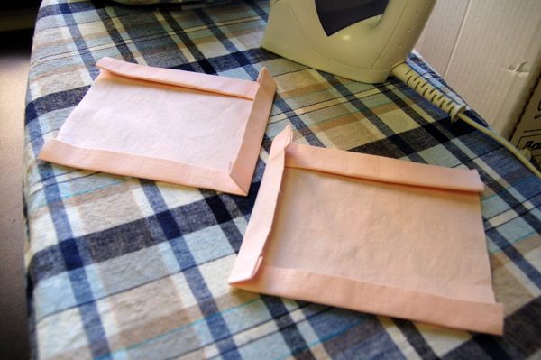 press under lower/left edges of one pocket, and lower/right edges of the other pocket